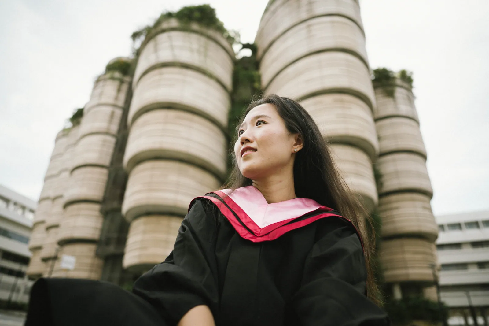 Master's graduate in gown in front of The Hive, NTU graduation photoshoot, Singapore