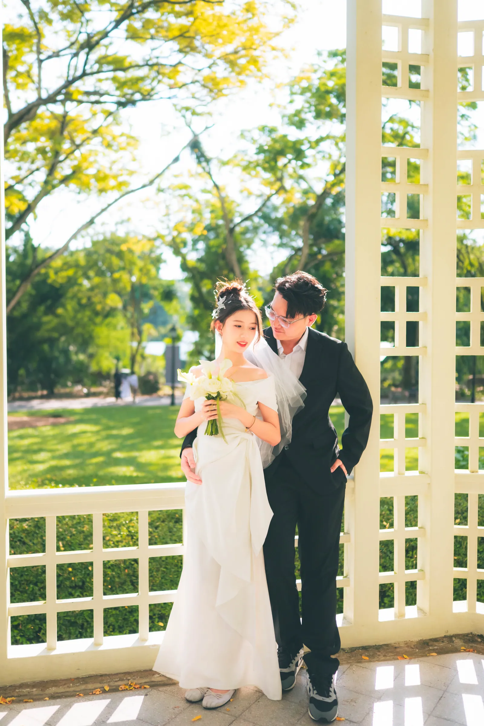 Bride with a calla lily bouquet and groom in a black suit at the white Bandstand in the Singapore Botanic Gardens, ROM photography